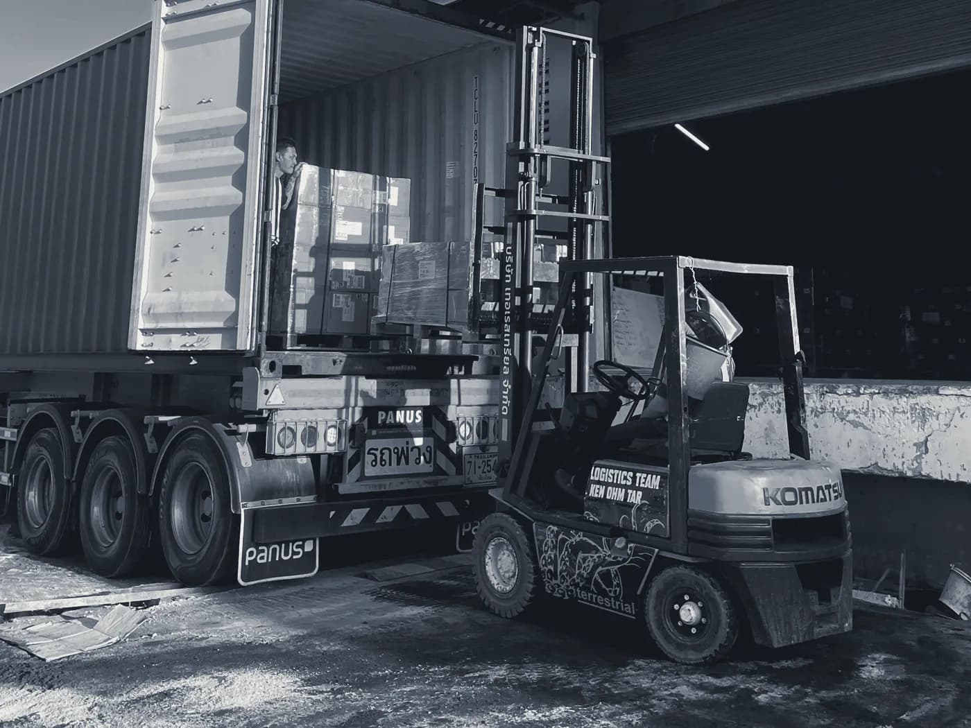 A forklift loading pallets into a container
